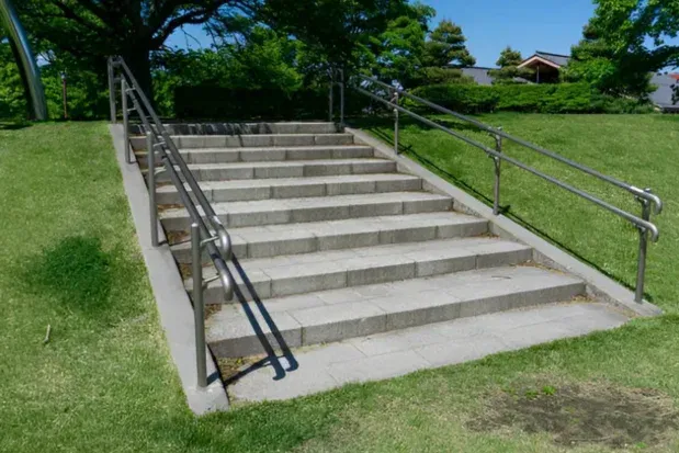 Exterior concrete staircase and landing with metal handrails